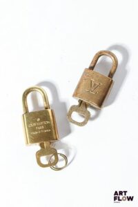 LOUIS VUITTON Ensemble de deux cadenas en métal doré monogrammés Hauteur : 4 cm