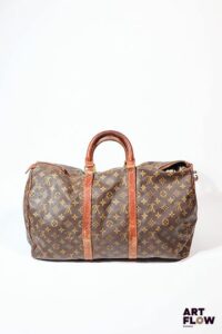 LOUIS VUITTON Modèle Keepall Sac de voyage vintage en toile enduite monogrammée et cuir. H. 31 x L. 50 cm environ Usures, fils tirés, taches