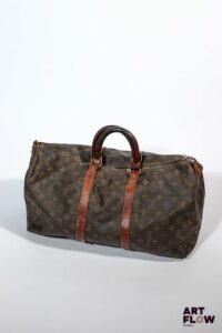 LOUIS VUITTON Modèle Keepall Sac vintage en toile enduite monogrammée et cuir Dimensions : 31 x 50 cm Taches, coutures effilochées, griffures, trou, cuir craquelé