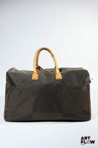 LOUIS VUITTON Paris Sac de voyage en toile damier et cuir naturel. Garniture en métal argenté. Fermeture zippée ornée d’un cadenas. Dim. anses non comprises : H. 35 x L. 56 cm x P.24 cm Usures d’usage notamment sur les parties en cuir, tâches.