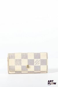 LOUIS VUITTON Porte clés en toile enduite beige et bleue, bijouterie en métal doré, fermoir à pression sous rabat. Dimensions : 5,5 x 10 cm Usures