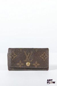 LOUIS VUITTON Porte clés en toile enduite monogrammée marron, bijouterie en métal doré, fermoir à pression sous rabat. Dimensions : 5,5 x 10 cm Usures