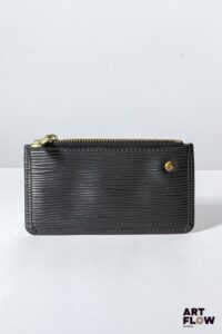 LOUIS VUITTON Porte monnaie en cuir épi noir, bijouterie en métal doré, fermeture éclair, garniture en cuir saffiano noir. Dimensions : 6,5 x 12 cm Bon état général (quelques marques d'usage)