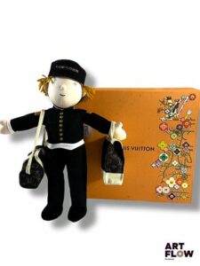 Louis Vuitton Poupée Bellboy avec ses 2 sacs Keepall. Édition limitée réservée aux clients VIP de la marque. Etat proche du neuf. L'emballage présente de légères traces du temps. - Expédition obligatoire.