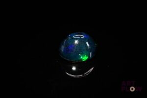 Opale noire cabochon ovale. Beaux éclats de couleur, dominante bleue. 2.86 cts. 11.0mm x 9.0mm