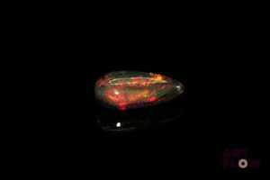 Opale noire cabochon poire. Beaux éclats de couleur, dominante rouge. 2.70 cts. 14.0mm x 7.5mm