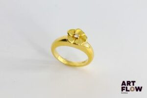 Poiray Bague en or jaune 750/°°, ornée d'une fleur centrée d'un petit diamant figurant son pistil. Très bon état général malgré quelques petites rayures d'usage. Poids brut : 6.39 gr TDD 48
