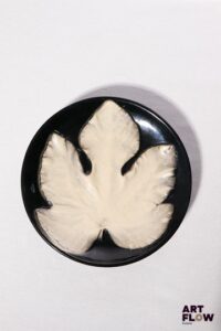 POL CHAMBOST (1906-1983) Assiette 864 "Feuille" en faience émaillée à couverte noire et blanche Tampon "864, Made in France" Diam. 23 cm Bibliographie : Philippe Chambost, "Pol Chambost, Sculpteur-Céramiste 1906-1983", Somogy Editions d'Art, Paris, 2006, modèle similaire p. 76