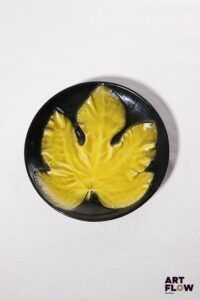 POL CHAMBOST (1906-1983) Assiette 864 "Feuille" en faience émaillée à couverte noire et jaune Tampon "Made in France" Diam. 23 cm Bibliographie : Philippe Chambost, "Pol Chambost, Sculpteur-Céramiste 1906-1983", Somogy Editions d'Art, Paris, 2006, modèle similaire p. 76