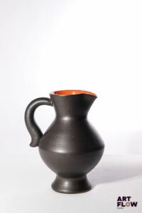 POL CHAMBOST (1906-1983) Pichet 835 en faience émaillée à couverte noire à l'extérieur et orange à l'intérieur. Incisé sous la base "835, Made in France, Poterie Pol Chambost" H. 24 cm Bibliographie : Philippe Chambost, "Pol Chambost, Sculpteur-Céramiste 1906-1983", Somogy Editions d'Art, Paris, 2006, modèle similaire p. 55