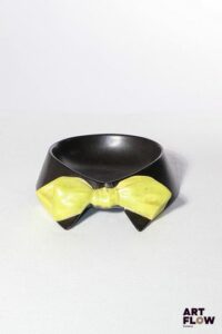POL CHAMBOST (1906-1983) Rare vide-poches 2078 en faience émaillée figurant un col de chemise et nœud papillon, à couverte noire et jaune. Incisé au revers "2078, Pol Chambost, Made in France" 17,5 x 15 x 4 cm