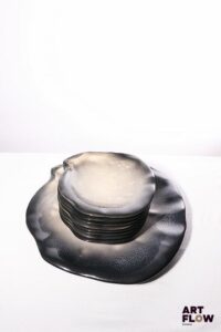 POL CHAMBOST (1906-1983) Service 1025 "Coquille" en faience émaillée à couverte polychrome dans les tons nacrés gris et bleus, comprenant un grand plat et 8 assiettes. . Assiettes incisées "1025, Poterie Pol Chambost, Made in France", le plat "1042, Poterie Chambost, France". Assiettes : 26 x 24,5 cm Plat : 45 x 42 cm Bibliographie : Philippe Chambost, "Pol Chambost, Sculpteur-Céramiste 1906-1983", Somogy Editions d'Art, Paris, 2006, modèle similaire p. 26 ; p. 95