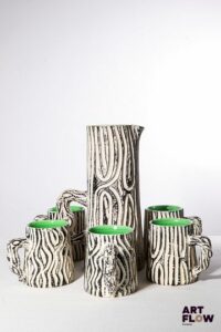 POL CHAMBOST (1906-1983) Service à orangeade 883 "Bois de bouleau" en faience émaillée à couverte polychrome, noire et blanche à l'extérieur et verte à l'intérieur, comprenant un pichet et 8 chopes. Pichet incisé "883, Pol Chambost, Made in France"et les chopes "Poterie Pol Chambost, 883, Made in France". H. pichet 27 cm H. chopes 10 cm Bibliographie : Philippe Chambost, "Pol Chambost, Sculpteur-Céramiste 1906-1983", Somogy Editions d'Art, Paris, 2006, modèle similaire p. 156