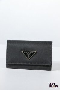 PRADA Porte clés en tissu noir, bijouterie en métal argenté, fermeture à pression sous rabat. Dimensions : 6 x 10 cm Bon état général