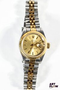 ROLEX Montre bracelet de dame, modèle Datejust, en or jaune 750/°° et acier, à mouvement mécanique à remontage automatique, le boîtier rond brossé à cadran à fond de doré, index bâtons, lunette cannelée en or jaune, bracelet jubilée. Années 1992 D. 26mm Longueur du bracelet : 16 cm env. Référence 69173 Poids brut : 57,5 gr Lancée en 1945, la Datejust est la première montre-bracelet à afficher la date automatiquement dans un guichet, symbole d’innovation et d’élégance intemporelle chez Rolex. Excellent état général. Fournie avec son set complet comprenant boîte, sur boîte, garantie, facture et tags d'origine. Fonctionnelle au moment de la rédaction du catalogue, mécanisme non garanti. Expert : AFB Expertises horlogerie