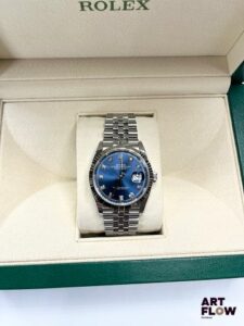 ROLEX Montre bracelet homme en acier, modèle Oyster Perpetual Datejust 36, à mouvement mécanique à remontage automatique, le boîtier de forme ronde à cadran à fond soleillé bleu, index points sertis de diamants, lunette cannelée en or blanc, guichet date à 3h, seconde centrale, le bracelet Jubilée poli-brossé. Années 2022 Diamètre 36mm Référence 126234 Introduite en 1945, la Rolex Datejust marque une étape majeure dans l’histoire de l’horlogerie. Elle est la première montre-bracelet automatique étanche à afficher la date dans un guichet. En 1953, Rolex ajoute la célèbre loupe Cyclope pour améliorer la lisibilité. Élégante et technique, la Datejust est devenue un modèle emblématique et intemporel. Neuve de stock (aucune trace d'usage, jamais portée) Fourni avec son set complet comprenant boîte, sur boîte, garantie, tags d'origine et manuel d'utilisation. Garantie datée de 2022 et donc encore valable jusqu'en 2027 Fonctionnelle au moment de la rédaction du catalogue, mécanisme non garanti. En raison de le l'état, la montre n'a pas été ouverte et le mécanisme n'a donc pas été vérifié. Expert : AFB Expertises horlogerie