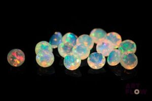 Seize opales facettées blanches rondes. Beaux éclats de couleur. 5.40 cts. Diam. moy.: 5.0mm