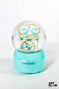 TIFFANY & CO Boule à neige faisant office de boîte à musique. L'intérieur figurant un carrousel. Édition limitée. Fonctionnelle. H. 15 cm Dans son coffret d'origine État neuf