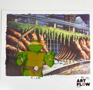 Tortues Ninja (Ninja Turtles) Michelangelo Cellulo à l’encre et à la gouache sur fond imprimé représentant Michelangelo portant un nunchaku Animé américain d'après la série Teenage Mutant Ninja Turtles créée par Kevin Eastman et Peter Laird "Les Ninja Turtles sont quatre frères mutants entraînés dans l’art du ninjutsu par leur maître Splinter. Leonardo, Michelangelo, Donatello et Raphael se distinguent chacun par leur personnalité et leur arme de prédilection, mais partagent courage, esprit d’équipe et sens de la justice. Ensemble, ils protègent New York des criminels et des forces du mal tout en vivant des aventures épiques et pleines d’humour." Dimensions : 28 x 35,5 cm