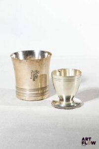 Une timbale en argent massif poinçon Minerve. Poids : 83,15 g. On y joint un coquetier en métal argenté.