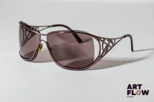YSL Paire de lunettes de soleil, les branches ornées du logo a strass. Quelques petites rayures. Dans un étui Dolce & Gabbana.