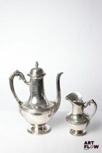 Théière et pot à lait en argent (poinçons Minerve), à décor de faisceaux enrubanés. Poids brut total : 1082,6 Petits accidents (enfoncement et pied tordu)