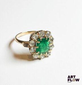 Bague en or jaune 750‰, poinçon hibou, de forme marguerite, sertie au centre d’une émeraude rectangulaire à pans coupés d’un magnifique vert (8.3x7.5mm), et entourée de 10 diamants taille ancienne ; le panier délicatement ajouré, le corps également mis en valeur par deux petits diamants. Quelques manques et accidents à l’émeraude. Poids : 4.62 g brut Diamants : 1 carat env. – Emeraude : 1.2 carat env. Tour de doigt : 52 Expertise : Philippine Vanheems