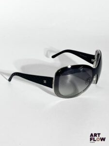 CHANEL Lunettes de soleil noires, motif matelassé sur les branches. Dimensions : H. 6 x L. 17 cm