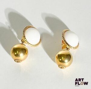 CHANEL Paire de clips d'oreilles en métal doré ornés d'une sphère et d'une demie sphère en verre opalin. Dimensions : H. 5 cm