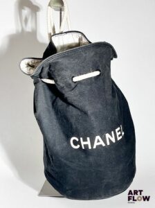 CHANEL Sac sceau en tissu noir, fermeture par cordon en tissu blanc, garniture intérieure en toile enduite blanche. Dimensions : H. 35 Tissu légèrement décoloré