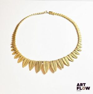 Collier en or jaune 750‰, poinçon tête de rhinocéros, entièrement composé de feuilles stylisées en chute ; fermoir cliquet et huit de sécurité. Travail Français de la 2 ème moitié du XXe siècle Poids : 34.76 g Longueur : 36 cm – largeur max : 1.8 cm Expertise : Philippine Vanheems