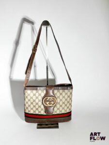 GUCCI Sac bandoulière en toile GG Supreme, tissu bicolore vert et rouge et cuir brun, bijouterie en métal doré, fermeture par bouton pression. Dimensions : H. 22 x L. 29 cm Garniture intérieure découpée