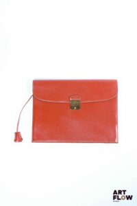 HERMÈS Modèle Jet Pochette porte-document en veau box brique, bijouterie en métal doré, et clés sous clochette. Signé, marqué « L’express » et chiffré à chaud : « C.D » Petites rayures et légères usures d’usage. Dim. : H. 28 x L.28 cm