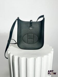 HERMÈS Paris Modèle Mini Evelyne Sac en cuir noir avec bandoulière, fermoir pression sous patte Dimensions : H.18 x L.18 cm Dans son dustbag et sa boîte d'origine