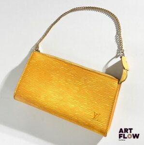 LOUIS VUITTON Pochette en cuir jaune, bijouterie en métal doré, fermeture éclair. Dimensions : H. 12,5 x L. 21 cm