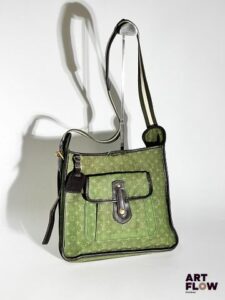 LOUIS VUITTON Sacoche en tissu Monogram vert et cuir marron, bijouterie en métal doré, bandoulière en tissu vert et blanc. Dimensions : H. 27 x L. 28 cm Déchirure au niveau de la couture supérieure. En l'état