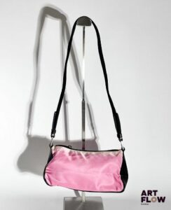 PRADA Sac bandoulière en nylon rose et cuir noir, bijouterie en métal argenté, fermeture éclair. Dimensions : H. 13 x L. 22 cm Décolorations
