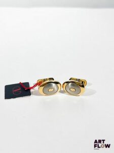 VALENTINO GARAVANI Paire de boutons de manchette produits sous licence Komai Co. au Japon. On y joint pince à cravate en métal argenté Mario Valentino Boutons de manchette : 2 x 1 cm env.