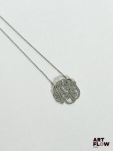 GINETTE NEW YORK Collier sur chaine et pendentif monogramme en or 18k (750/1000) Signé Pendentif : 17 mm environ Poids brut : 2,19 g Dans son pochon