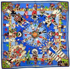 HERMÈS Modèle Kachinas d'après le dessin Olivier Kermit Carré en twill de soie dans les tons bleus Dimensions : 90 x 90 cm Micros trous et petites taches Bibliographie : Genevieve Fontan, Carrés d'art, Dictionnaire illustré des carrés Hermès valeur, 2025