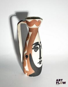 Pablo PICASSO (1881-1973) & ATELIERS MADOURA – VALLAURIS (céramiste) Pichet « Visage », modèle créé en 1955. Pichet tourné, réplique authentique en terre de faïence blanche. Décor aux engobes, émail rouge et noir. Edition à 500 exemplaires (infimes manques dans le décor, salissures, petits accidents à la couverte) Signé du cachet Edition Picasso, Madoura plein feu et marqué au noir Edition Picasso, Madoura. Haut. 31,5 cm Bibliographie : Alain Ramié, Picasso, catalogue de l’œuvre céramique édité 1947-1971, éditions Madoura, Vallauris, 1988, modèle référencé sous le n°288 et reproduit p. 150. Expert : Cabinet Marcilhac