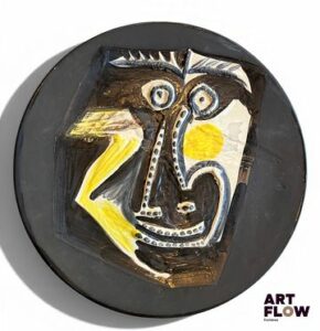 Pablo PICASSO (1881-1973) & ATELIERS MADOURA – VALLAURIS (céramiste) Plat rond « Visage », modèle créé en 1960. Empreinte originale en terre de faïence blanche, décor aux engobes sous couverte partielle au pinceau ; ivoire, jaune, bleu, brun, noir mat. Tiré à 100 exemplaires (petits éclats en bordure et sous le talon et défaut de matière en façade). Signé du cachet Empreinte originale Picasso, Madoura plein feu et justifié au noir 96/100. Diam. 42 cm Bibliographie : Alain Ramié, Picasso, catalogue de l’œuvre céramique édité 1947-1971, éditions Madoura, Vallauris, 1988, modèle référencé sous le n°446 et reproduit p. 234. Expert : Cabinet Marcilhac
