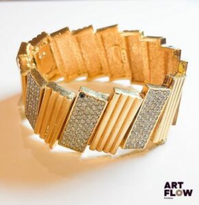 BALMAIN Bracelet manchette en métal doré à décor d'une alternance de rectangles à rainures et pavés de strass Longueur interne 6 cm H 3 cm