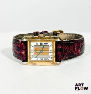 CARTIER Must de Cartier Modèle Tank "Trinity" en vermeil et plaqué or. Le cadran en or rose, blanc et jaune rappelle la bague « Trinity 3 ors », une configuration rare pour ce modèle. Mouvement à remontage quartz. Cadran avec chiffres romains, bracelet en cuir et cabochon de saphir bleu sur le remontoir. Poids brut : 20,10 g Dimension du cadran : 21 x 28 mm Dimension avec bracelet : 19 cm Quelques oxydations sur le cadran, marques d'usures sur le bracelet. Non ouverte au moment de la rédaction du catalogue, mouvement non garanti, changement de pile à prévoir. Expert : Alexis Francis Boeuf