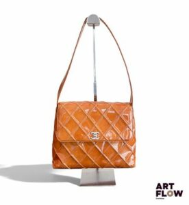CHANEL Sac à main de forme trapèze en cuir verni caramel, à fermoir pivotant en métal argenté à motif du double C, 2002 22 x 31 cm Petites traces et accident sur l'anse. Modèle de Soldes (porte un "S")