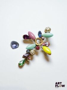 Christian LACROIX Broche pouvant former pendentif en métal doré ornée de pierres et perles d'imitation Pierre d'imitation centrale à refixer L 6,5 cm