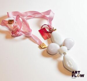 Christian LACROIX Important pendentif en métal doré orné de pierres blanches d'imitation Retenu par un lien en tissu rose H pendentif 10,5 cm Dans sa boîte