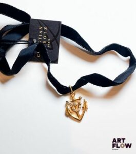 Christian LACROIX Pendentif en métal doré formant ancre ornée de strass, sur lien en velours noir Longueur 70 cm env