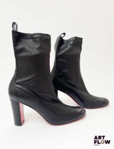 CHRISTIAN LOUBOUTIN Paire de bottines à talons noires en cuir synthétique Pointure 38,5 Hauteur du talon 9 cm Infimes traces à l'avant, semelles légèrement usées Avec un dustbag