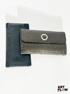 Ensemble comprenant deux portefeuilles : SALVADORE FERROGAMO Portefeuille noir Dimension fermée : 9,5 x 18 cm Marques d'usage notamment sur la tranche BULGARI Portefeuille marron monogrammé, fermoir à bouton-pression, intérieur en cuir synthétique Dimension fermée : 10 x 19 cm Bon état général malgré des traces d'usure à l'intérieur